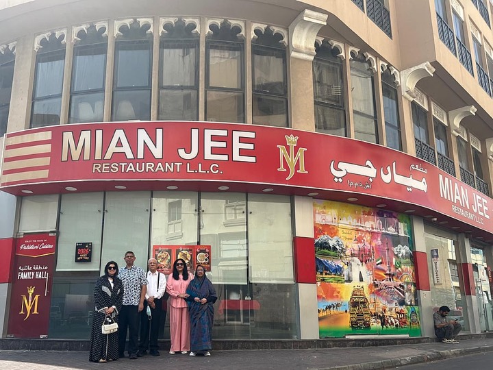 The family outside the building of their first home near Fish Roundabout, Deira