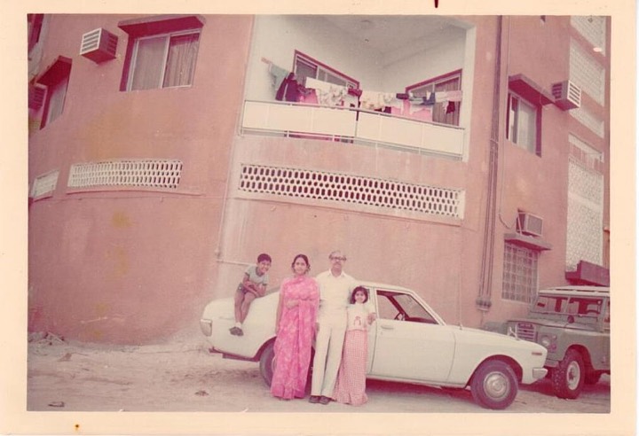 1970s photo of a family beside a white car outside their first Dubai flat