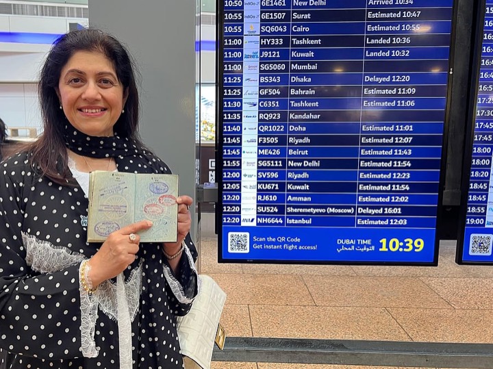 Dr Tasneem holding the passport open at the 1976 arrival stamp